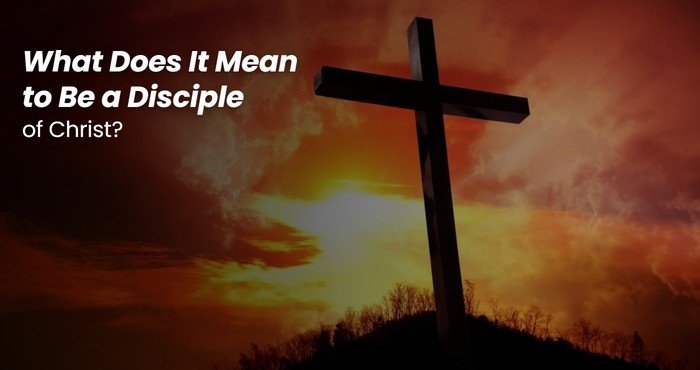 Wooden cross on a hilltop against a fiery sunset sky, a call to be a disciple of Christ